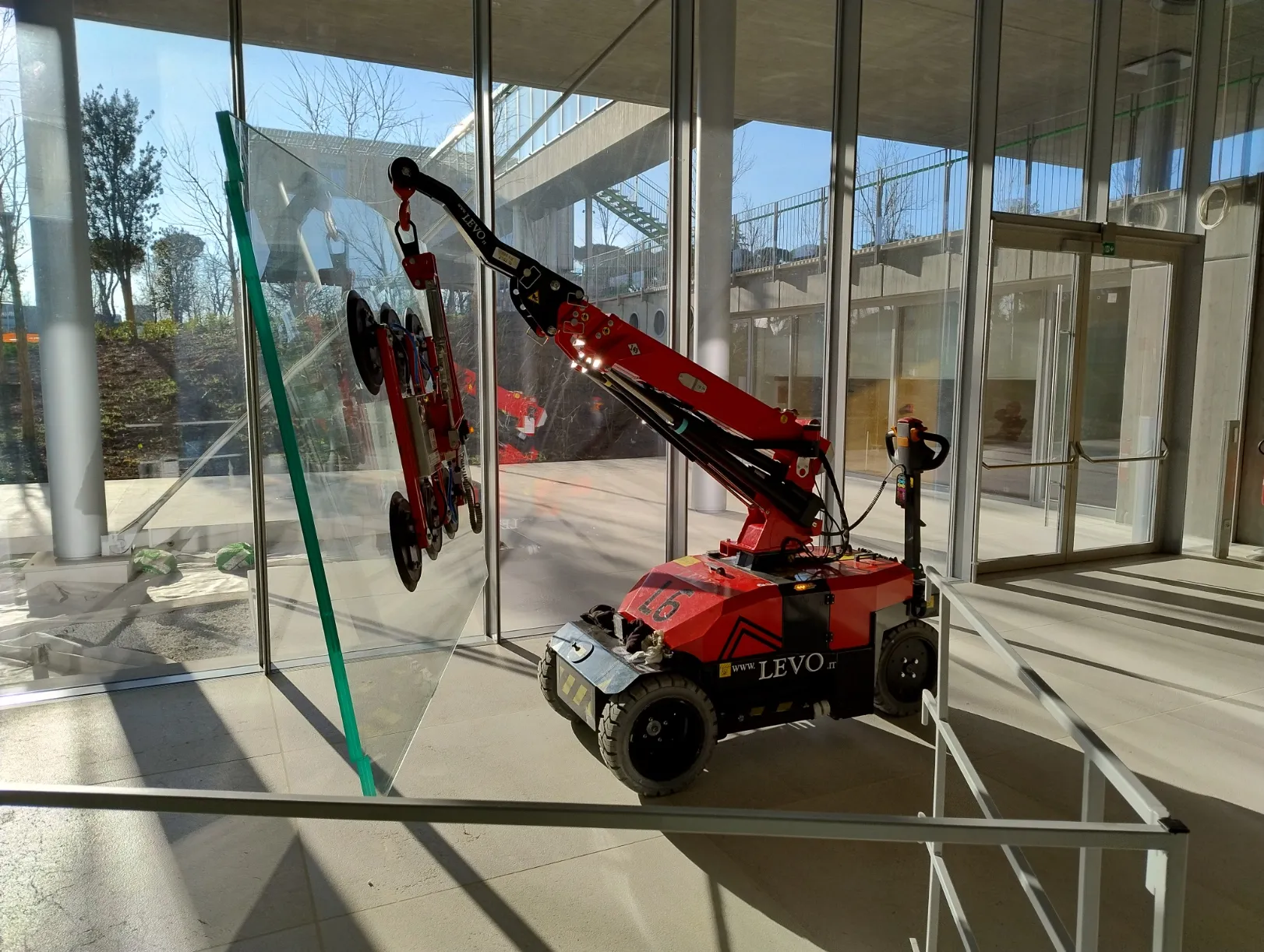 Robot ORION di LEVO durante la posa di una vetrata in cantiere